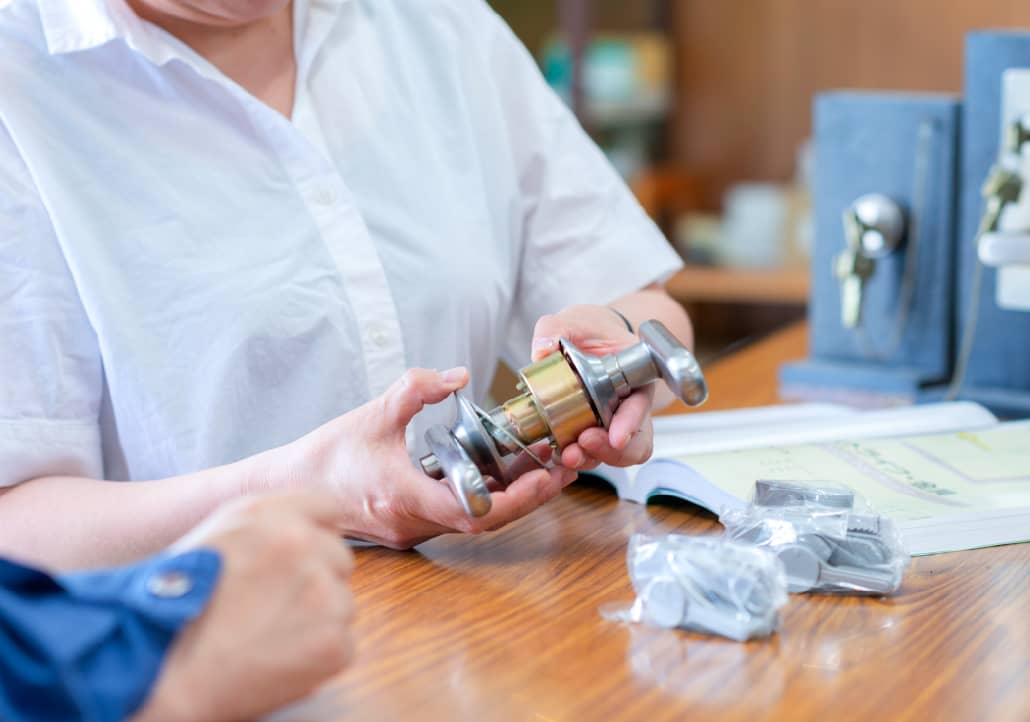 ドアノブの部品を持ってヒアリングを行うスタッフ